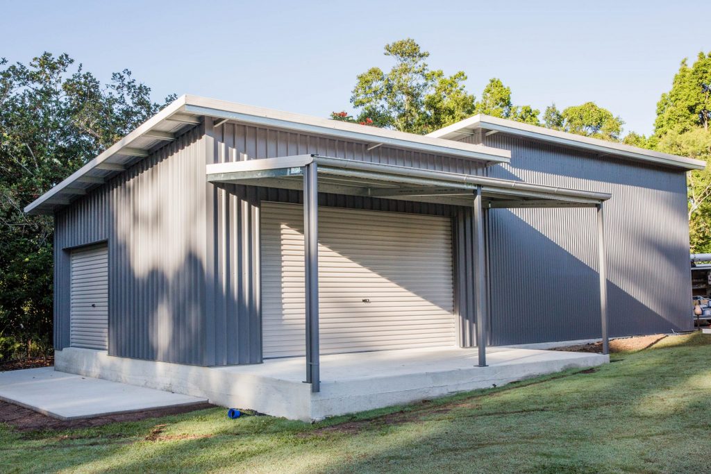 light grey and white caboolture shed with awning and two roller doors