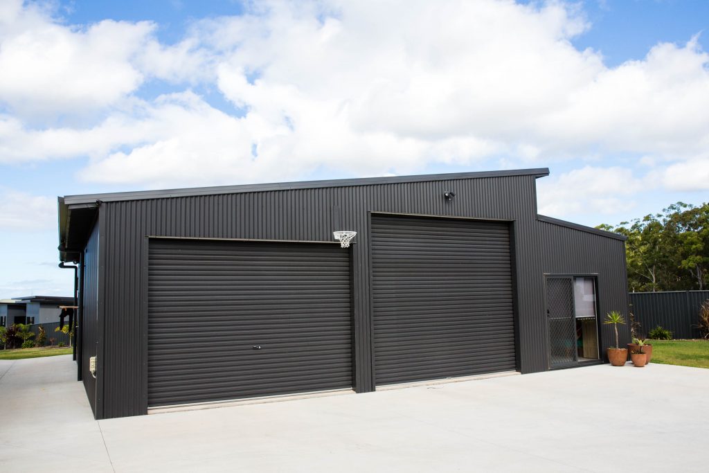 dark grey steel residential shed with basketball hoop